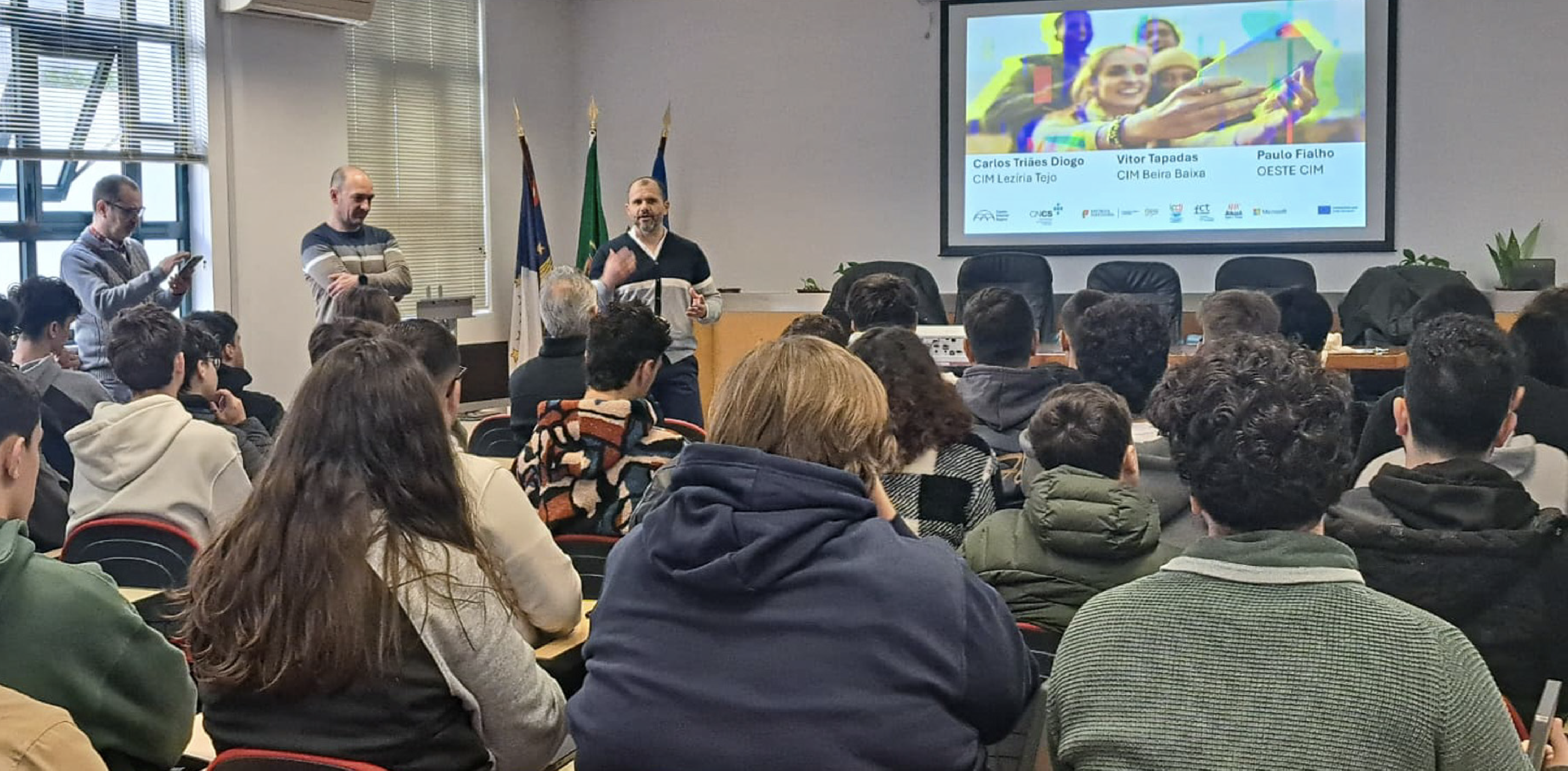 jovens numa sala de aula a ouvir adultos 